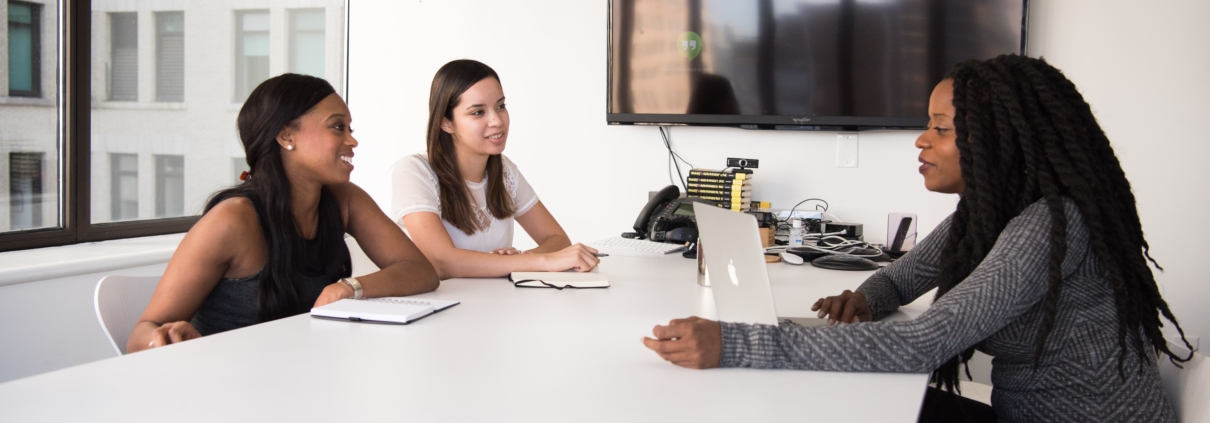 Women Sitting at a Conference Table Discussing