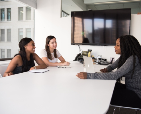 Women Sitting at a Conference Table Discussing