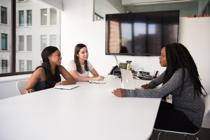 Women Sitting at a Conference Table Discussing